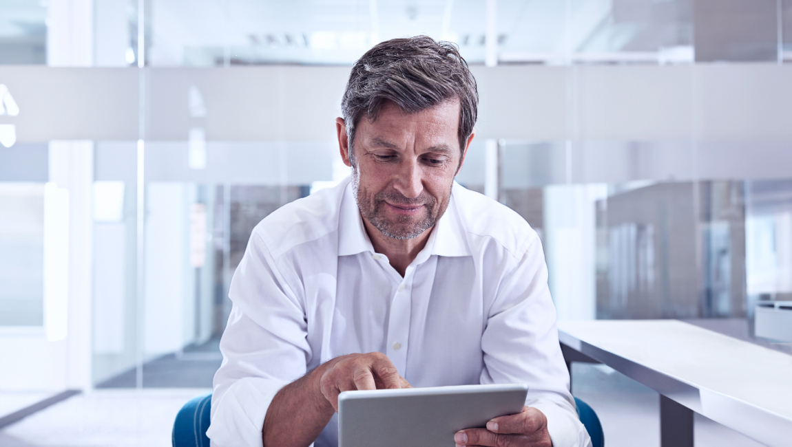 Businessman in modern office looking at tablet