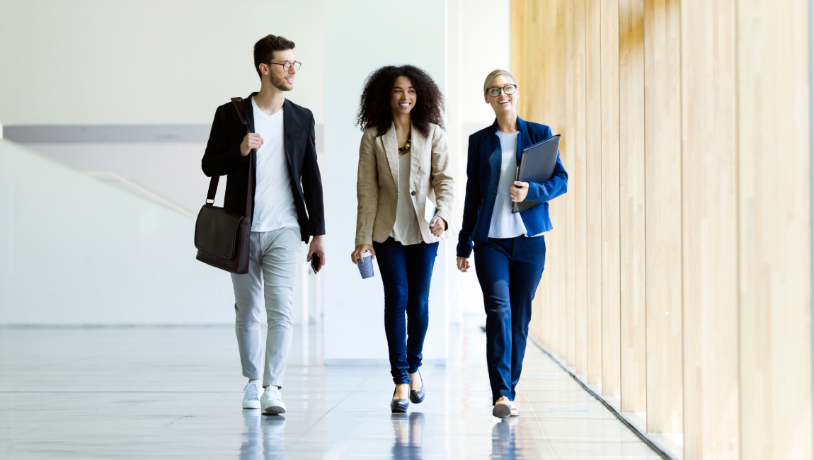 Three colleagues walking together down hallway