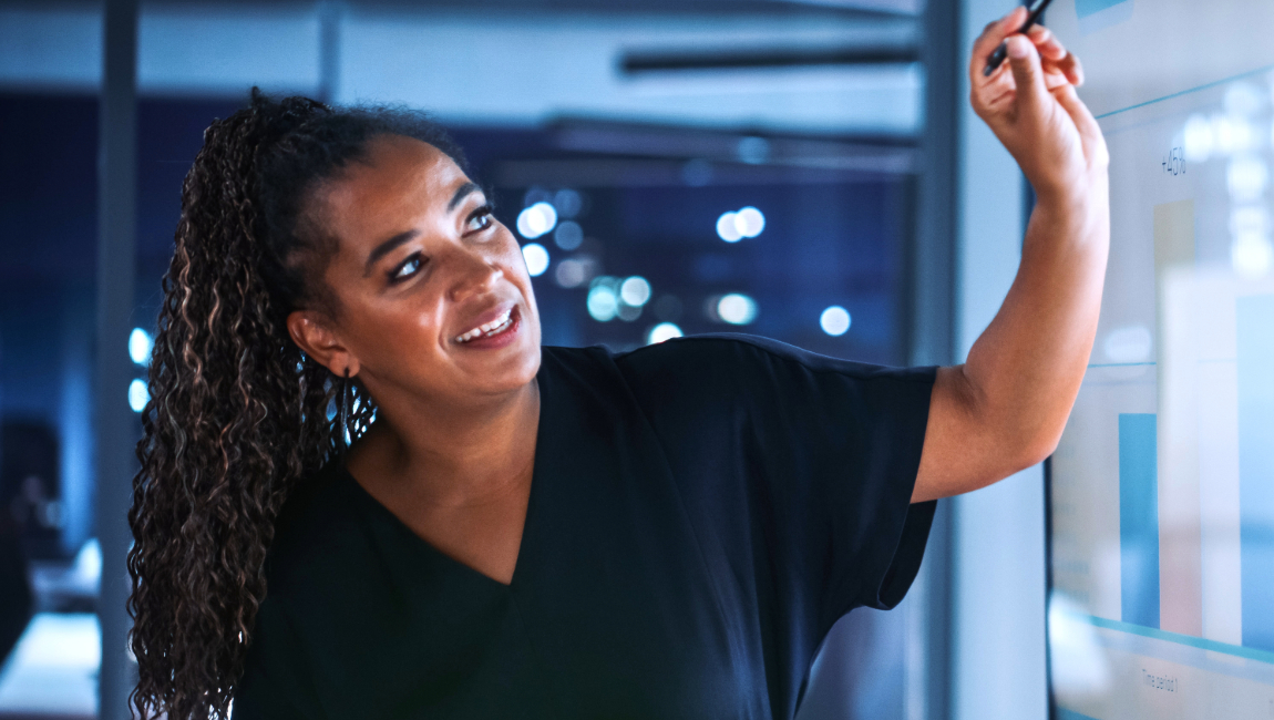 Business woman presenting and pointing at interactive screen